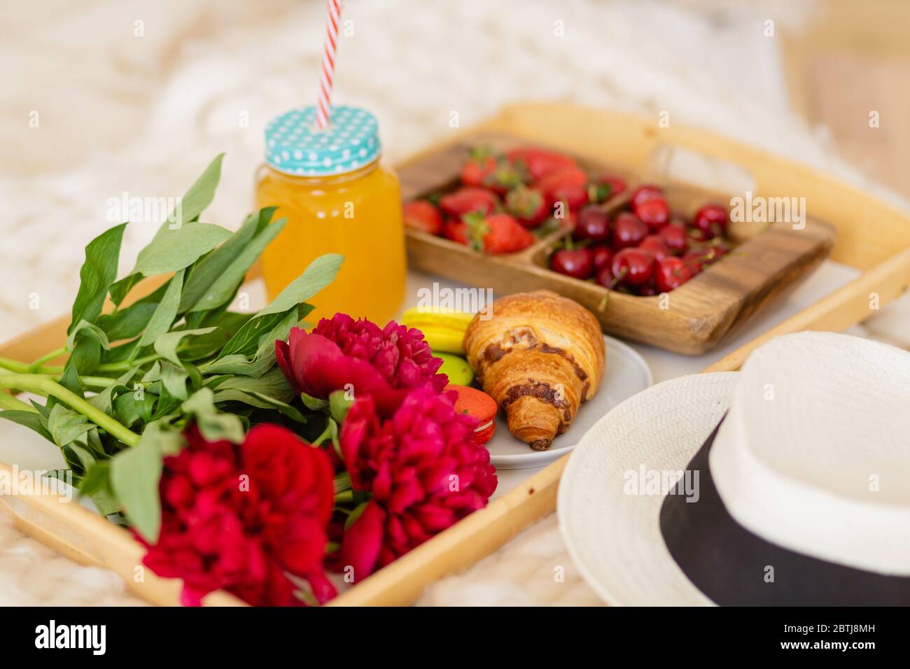 petit déjeuner au lit avec café, croissants, fraises et jus de fruits Banque D'Images