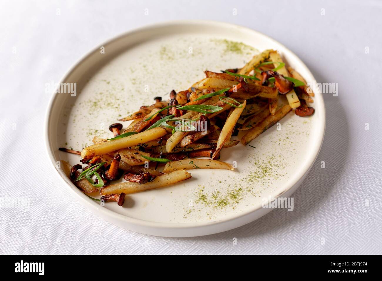 Pommes de terre frites savoureuses avec table blanche aux champignons Banque D'Images