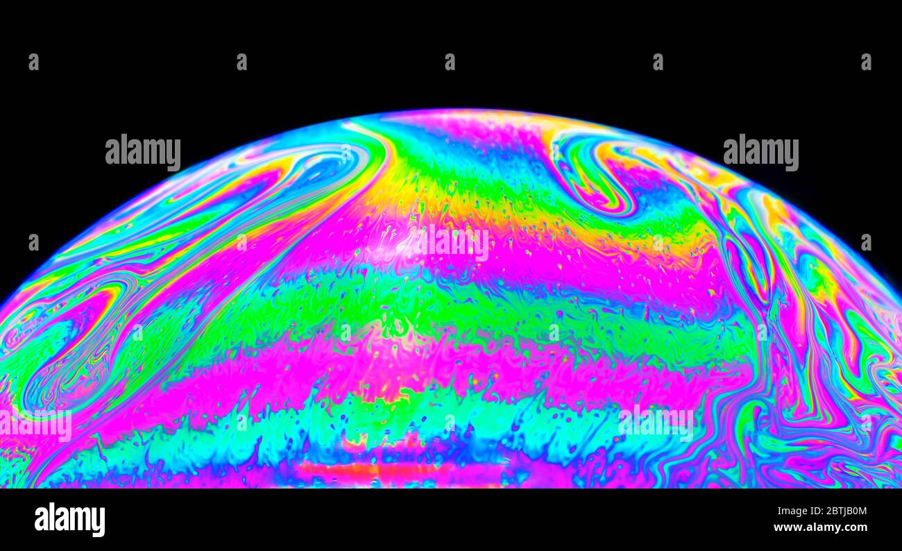 Gros plan Kaléidoscope de bulles colorées tourbillonnantes photographiées en studio avec un fond noir Banque D'Images