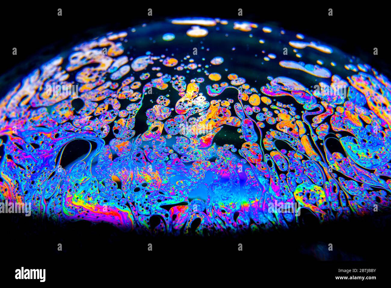 Gros plan Kaléidoscope de bulles colorées tourbillonnantes photographiées en studio avec un fond noir Banque D'Images