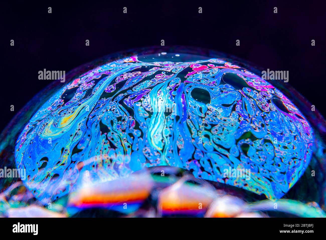 Gros plan Kaléidoscope de bulles colorées tourbillonnantes photographiées en studio avec un fond noir Banque D'Images