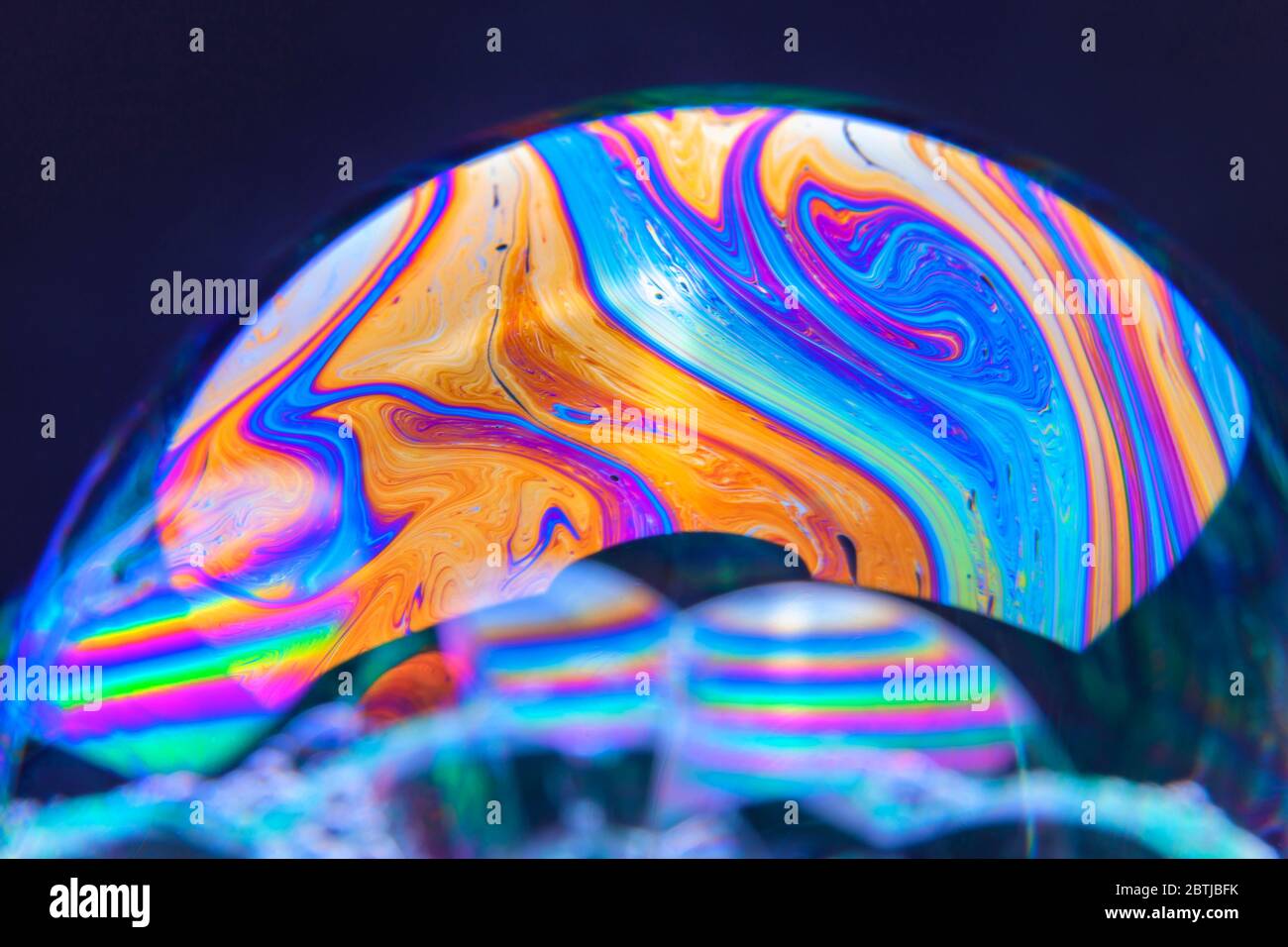 Gros plan Kaléidoscope de bulles colorées tourbillonnantes photographiées en studio avec un fond noir Banque D'Images