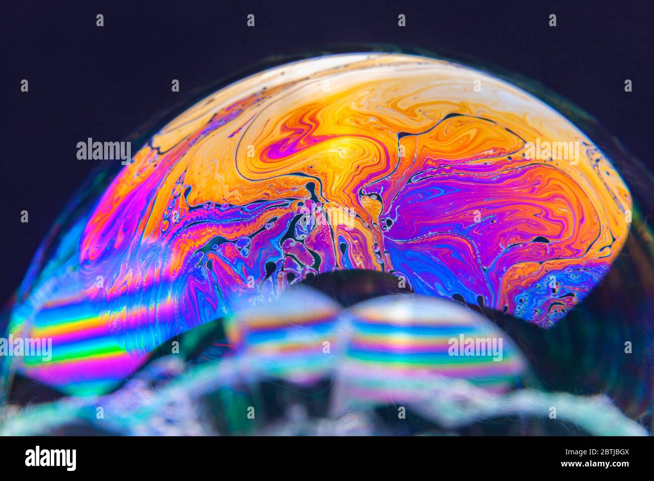 Gros plan Kaléidoscope de bulles colorées tourbillonnantes photographiées en studio avec un fond noir Banque D'Images