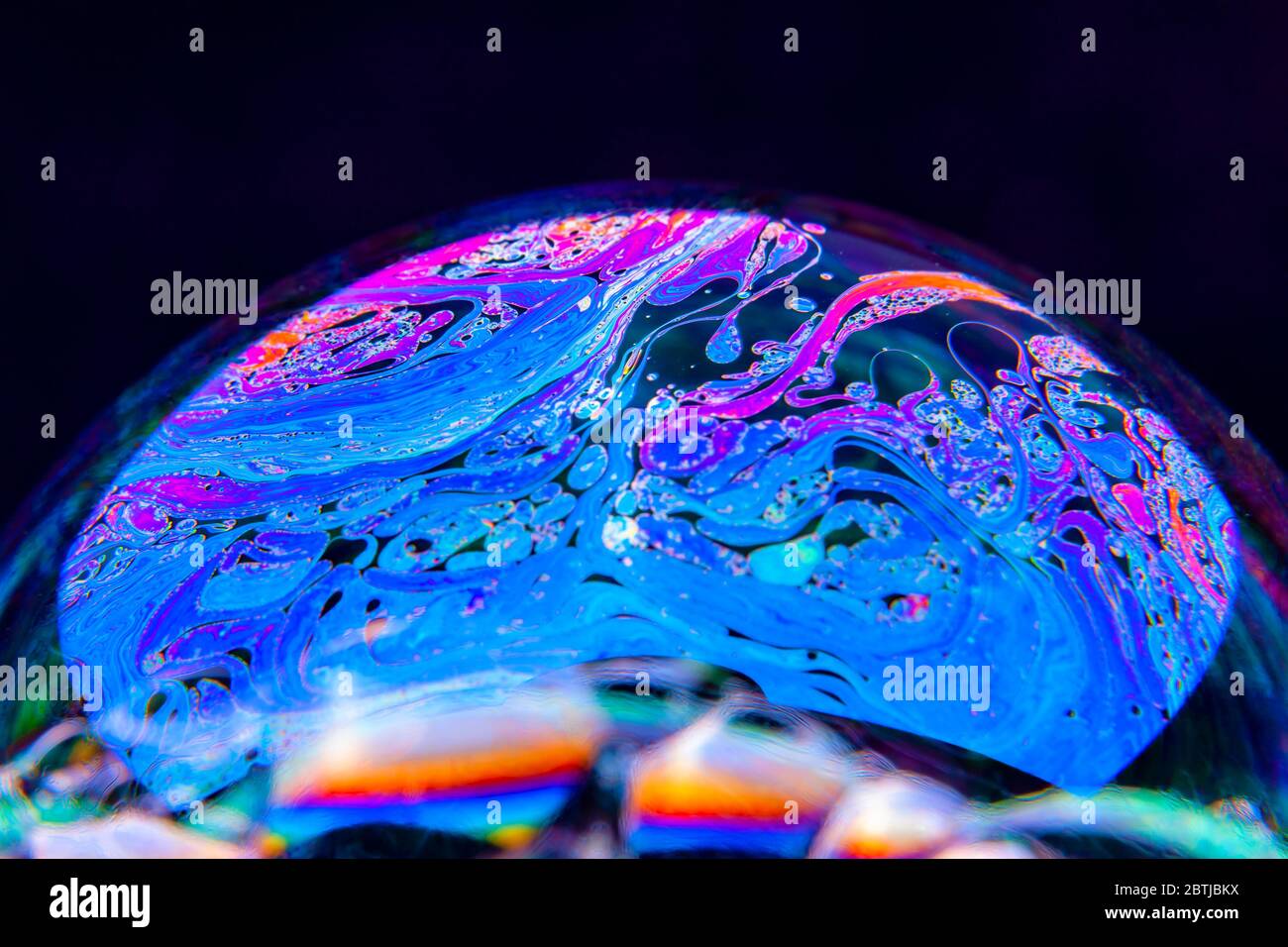 Gros plan Kaléidoscope de bulles colorées tourbillonnantes photographiées en studio avec un fond noir Banque D'Images
