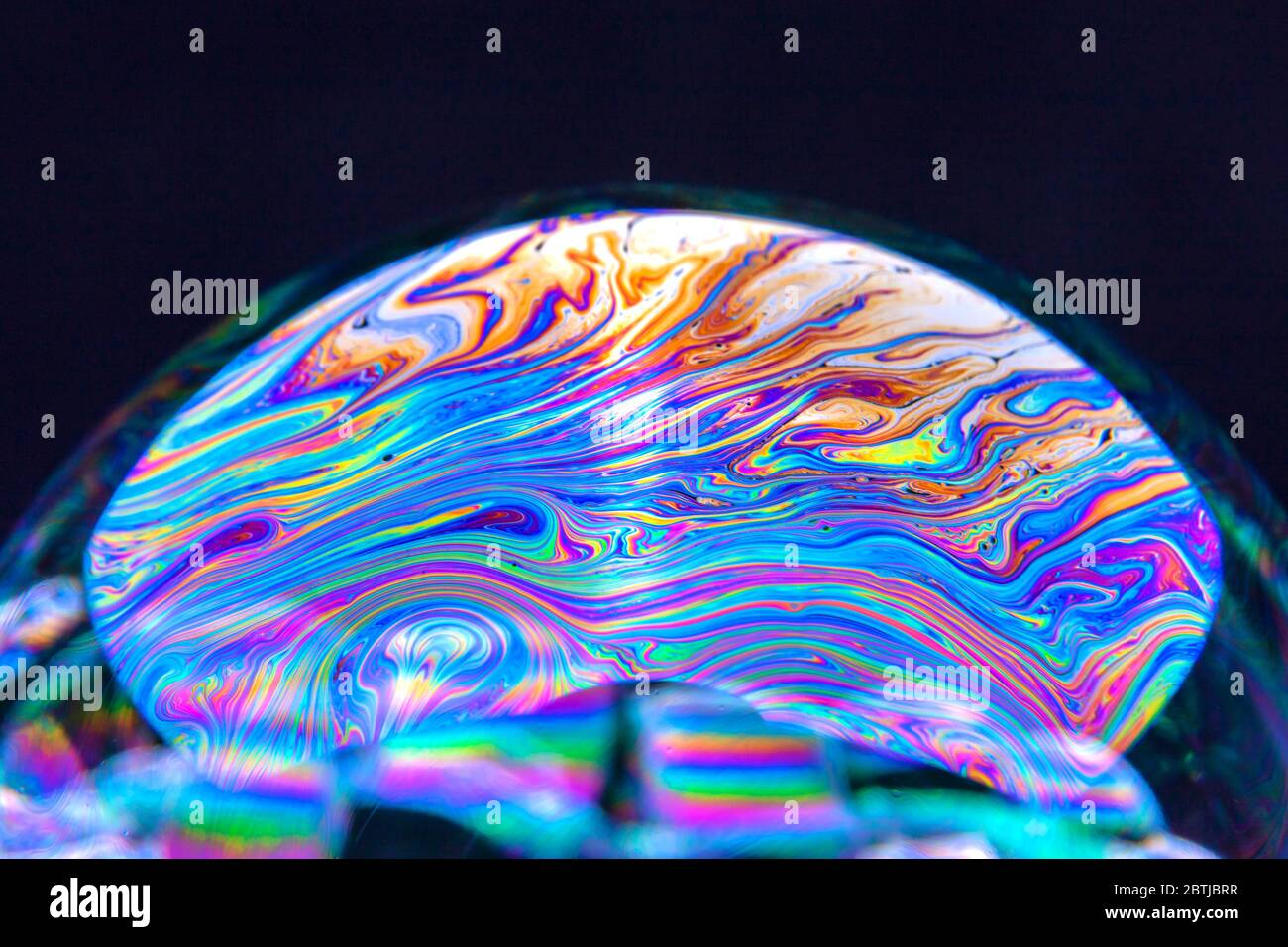 Gros plan Kaléidoscope de bulles colorées tourbillonnantes photographiées en studio avec un fond noir Banque D'Images