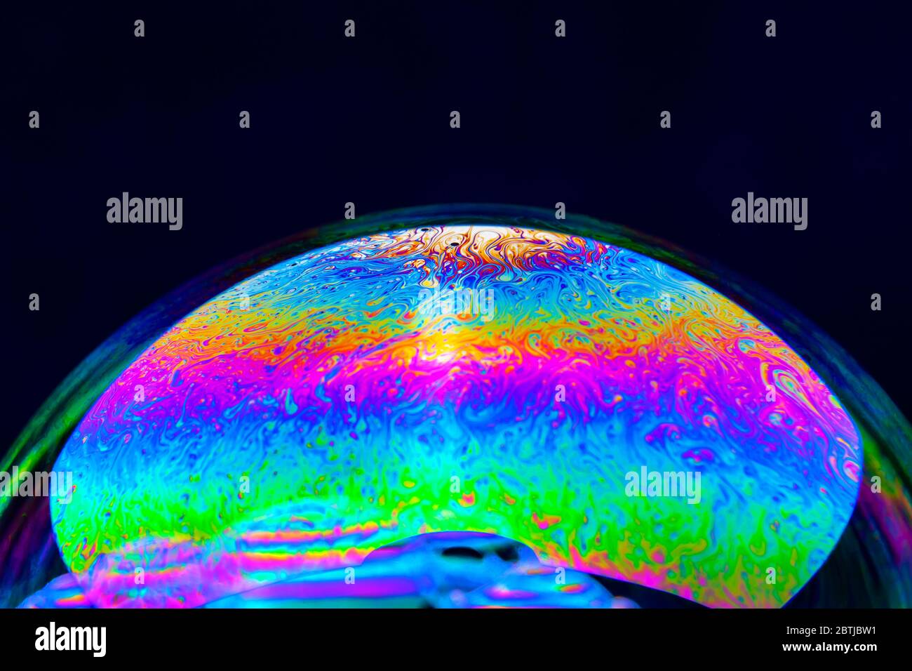 Gros plan Kaléidoscope de bulles colorées tourbillonnantes photographiées en studio avec un fond noir Banque D'Images