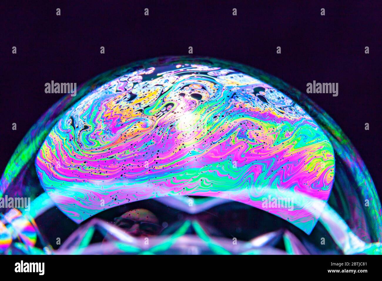 Gros plan Kaléidoscope de bulles colorées tourbillonnantes photographiées en studio avec un fond noir Banque D'Images
