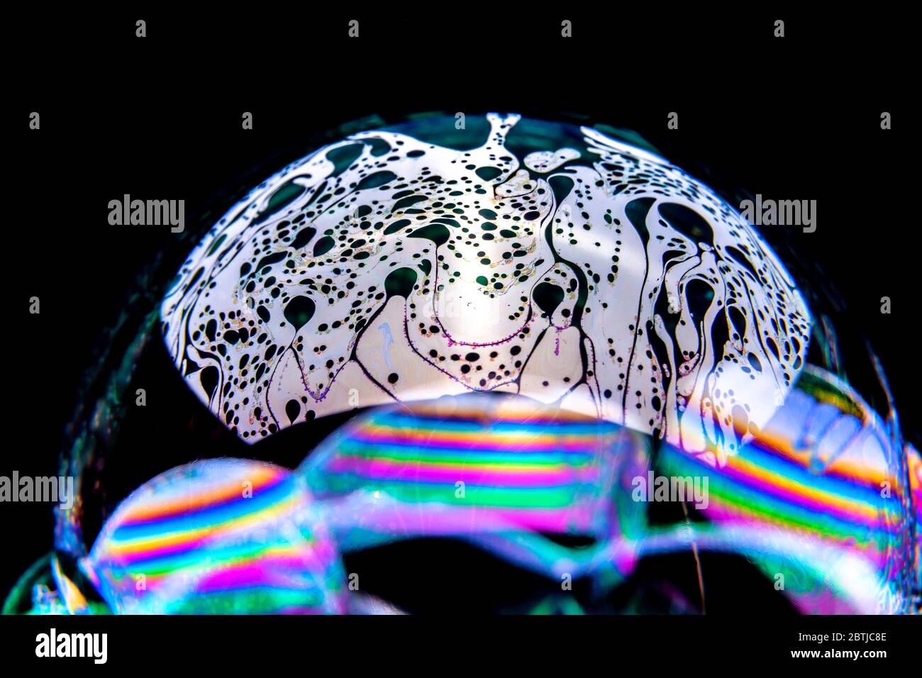 Gros plan Kaléidoscope de bulles colorées tourbillonnantes photographiées en studio avec un fond noir Banque D'Images