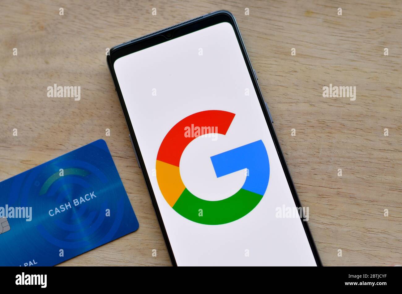 Californie, États-Unis, 2020. Pose à plat avec logo Google sur un écran mobile et carte de crédit cashback sur fond de bois. Banque D'Images