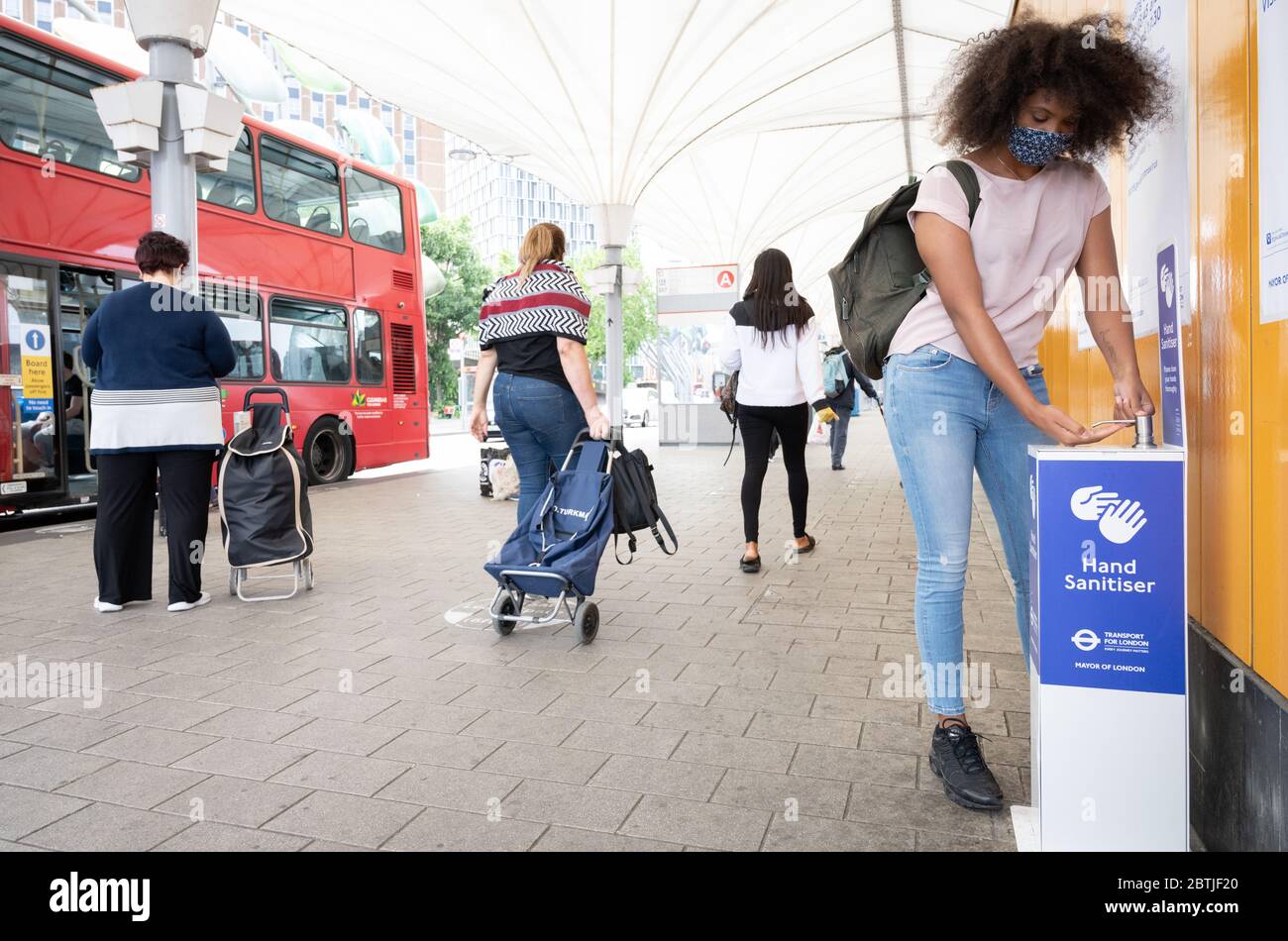 Les navetteurs utilisent un point désinfectant pour les mains à la gare routière de Stratford. Londres, Royaume-Uni. Mai 2020 Banque D'Images