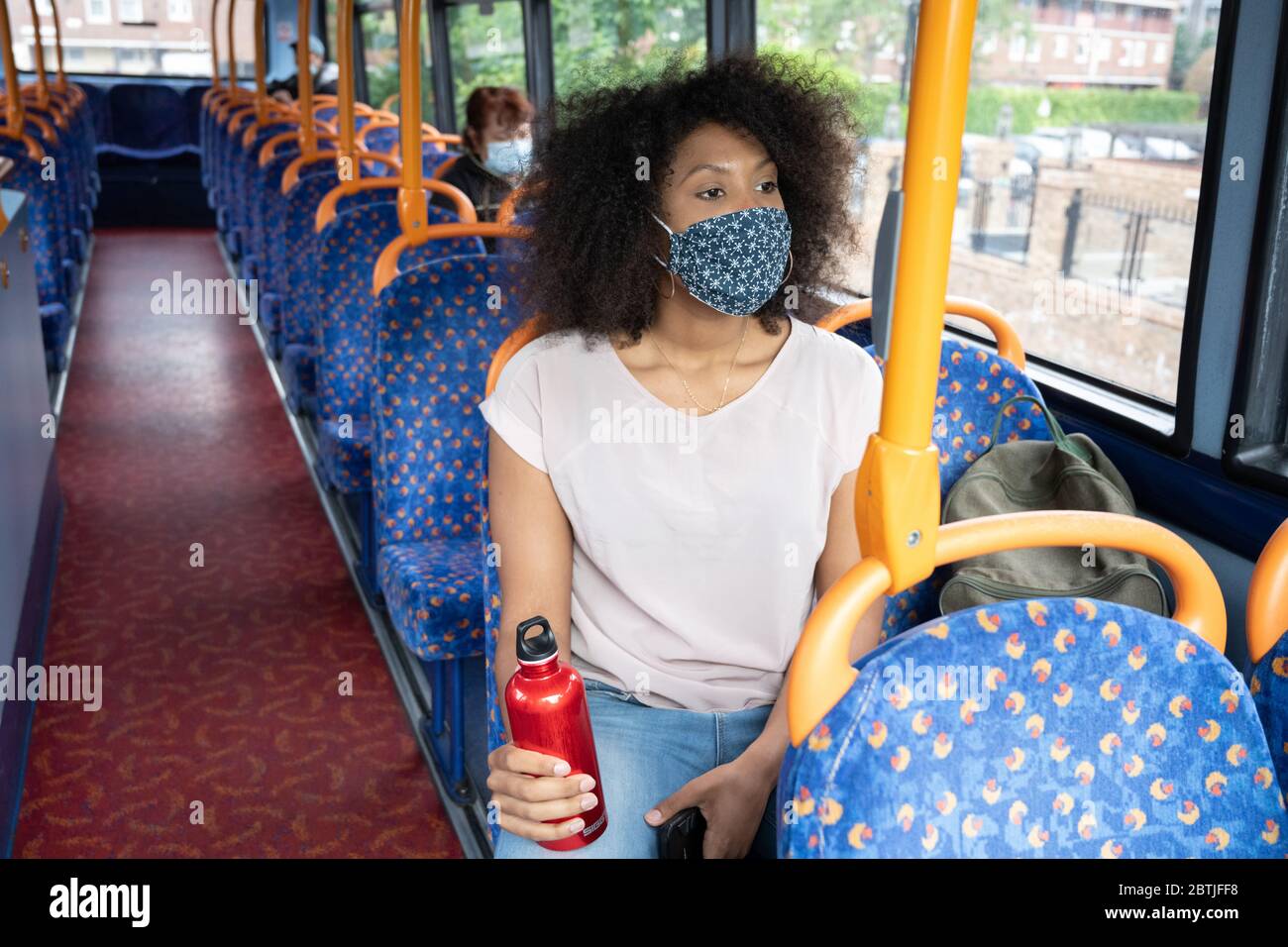 Les voyageurs portent un revêtement facial sur les bus londoniens lorsqu'ils retournent au travail. Mai 2020 Banque D'Images