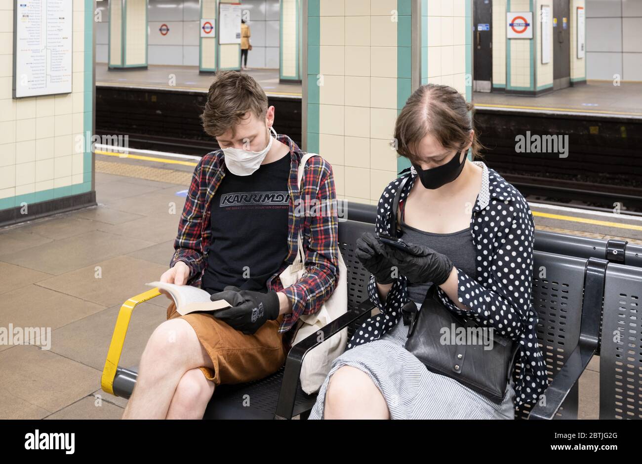 Les personnes qui voyagent pour les déplacements portent un revêtement facial sur le métro de Londres lorsqu'elles retournent au travail. Mai 2020 Banque D'Images