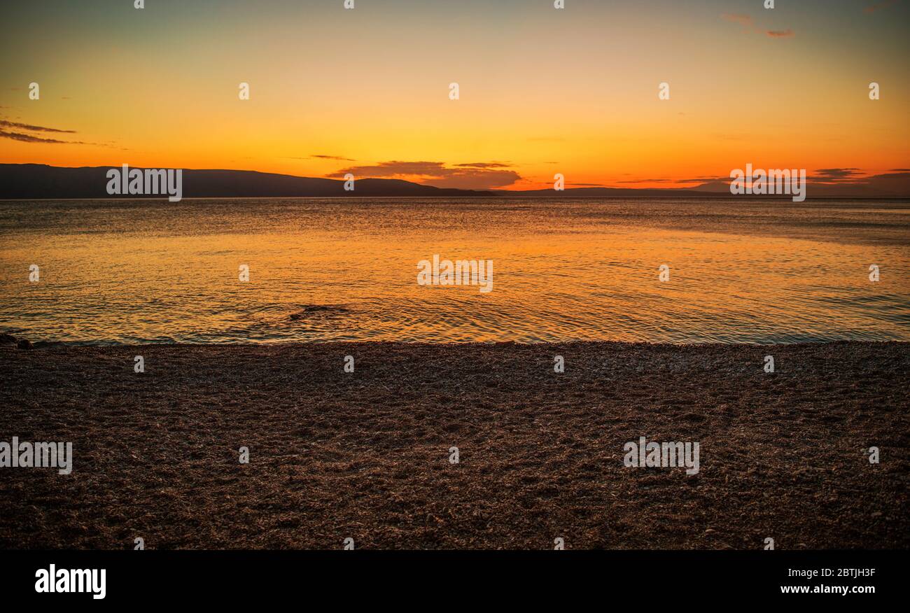Paysage croate. Côte de la Méditerranée temps d'été panoramique coucher de soleil. Rocky Beach et Calm Bay Water. Banque D'Images