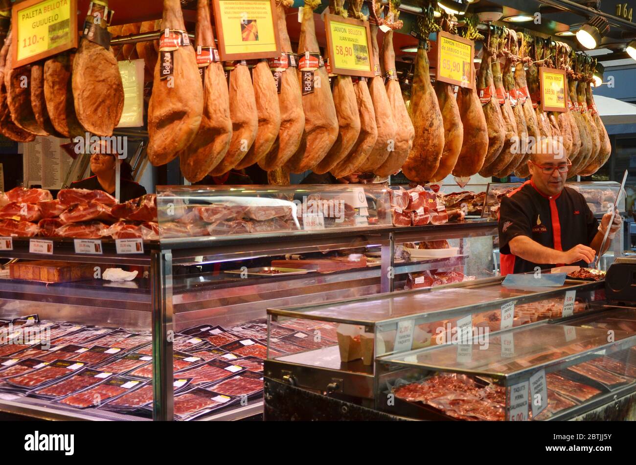 Un homme qui coupe le jambon de jamon au marché de barcelone. Jamón est une sorte de jambon sec-fumé produit en Espagne. Banque D'Images