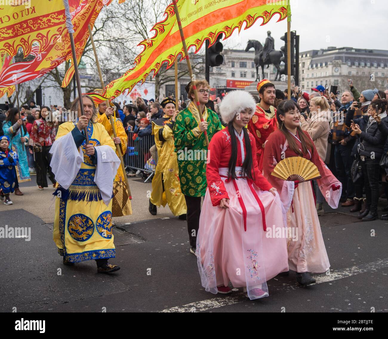 Femmes et hommes vêtir de la robe traditionnelle chinoise avec des fans et des drapeaux. Parade de la célébration du nouvel an chinois. Londres Banque D'Images