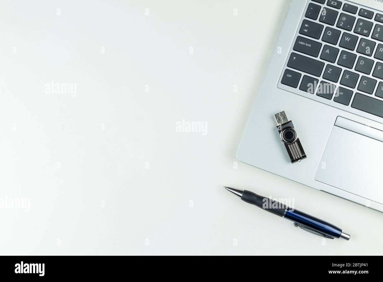 L'ordinateur portable, le stylet et la clé USB sont sur un arrière-plan blanc, vue de dessus. Banque D'Images