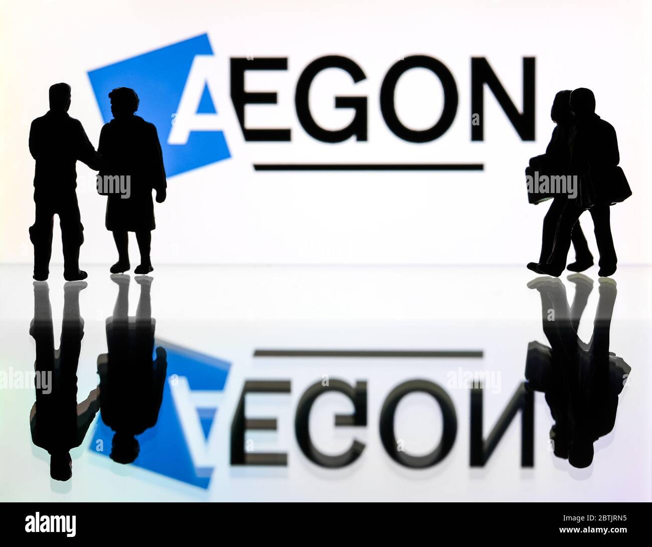 Silhouettes devant le logo d'Aegon, un fournisseur de services financiers. (usage éditorial uniquement) Banque D'Images