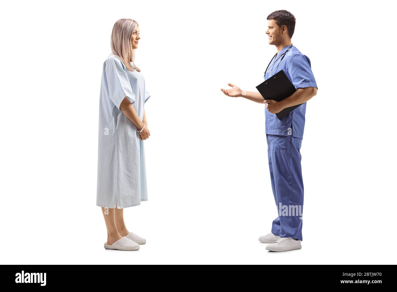 Photo de profil d'un médecin et d'une femme dans une robe de patient ayant une conversation isolée sur fond blanc Banque D'Images