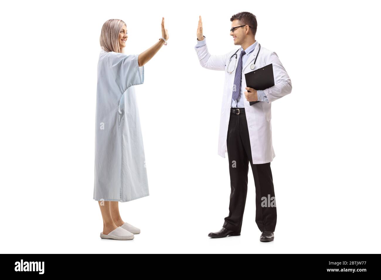 Prise de vue en profil d'un médecin et d'une femme en robe de patient, en gestuelle, d'un haut-cinq isolé sur fond blanc Banque D'Images