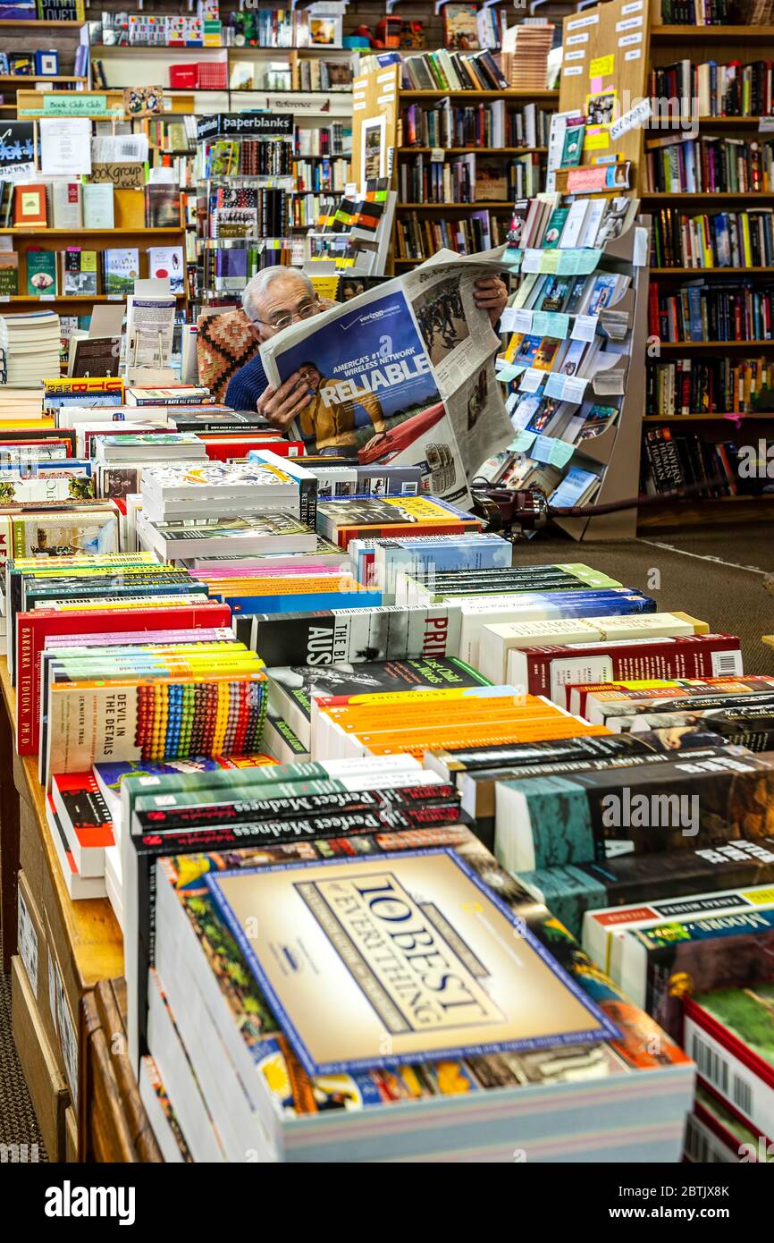 Homme lisant du papier, des livres, Bookworks Bookstore, Albuquerque, Nouveau-Mexique, Etats-Unis Banque D'Images