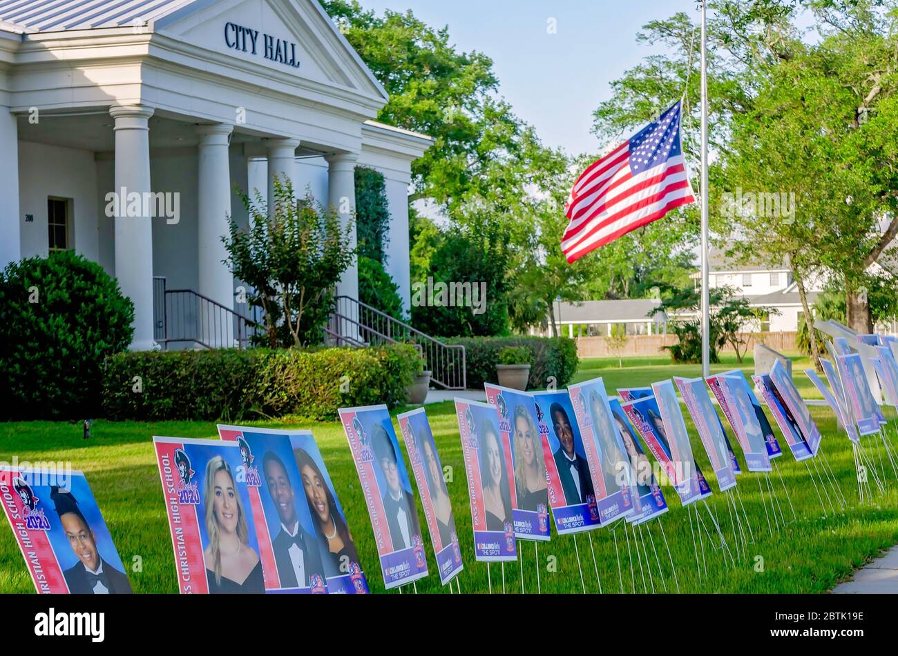 Portraits des aînés du secondaire de Pass Christian devant l'hôtel de ville, un drapeau vole à la moitié du personnel en l'honneur des victimes de la pandémie COVID-19. Banque D'Images