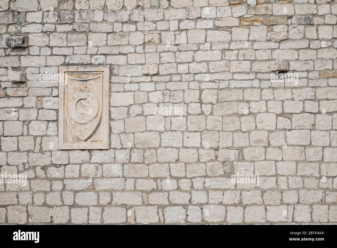 Détail architectural d'un vieux mur en pierre avec sculpture médiévale en plaque, dans la vieille ville historique de Split, Croatie Banque D'Images