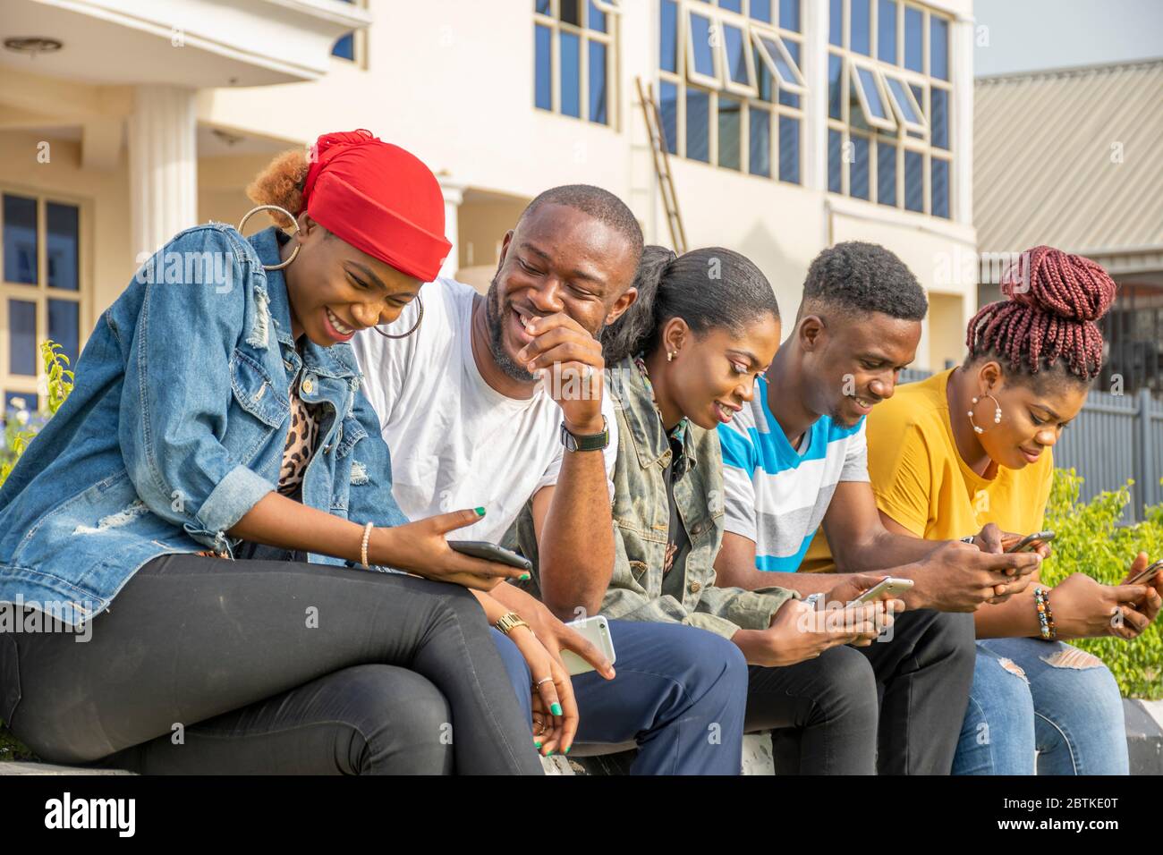un groupe de jeunes africains qui se traînaient ensemble à l'extérieur, s'amusent, rient Banque D'Images
