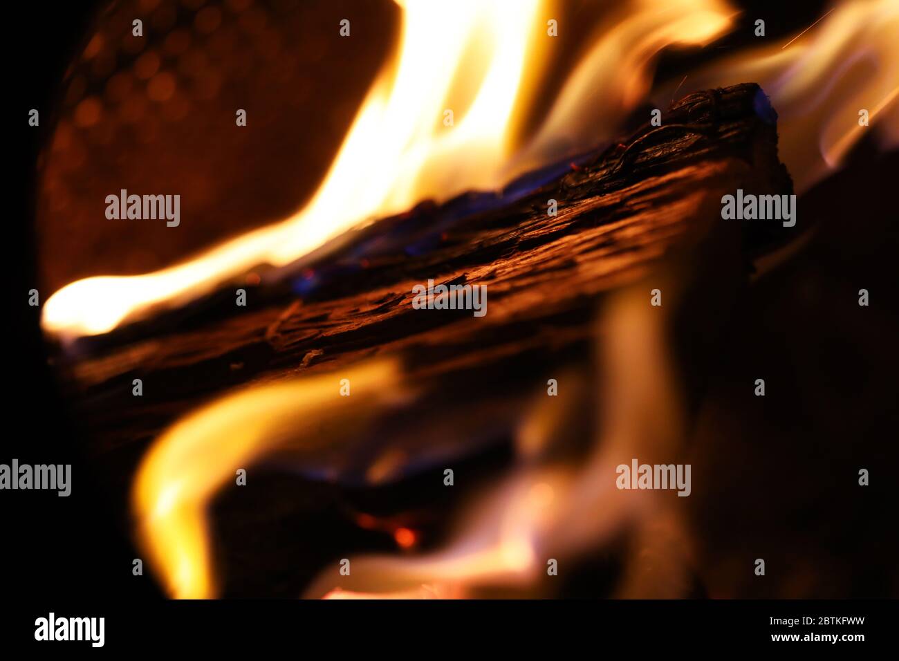 Une fosse brûlante de bois pendant une nuit froide, des flammes dansant autour de faire des œuvres d'art. Images capturées en gros plan dans des couleurs vives pour réimpression ou arrière-plan. Banque D'Images