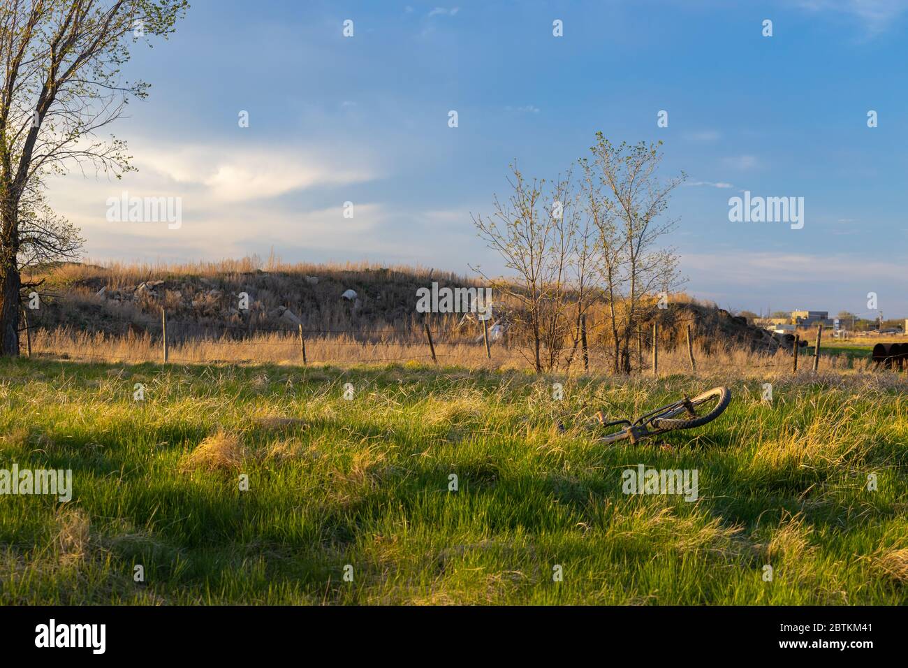 Une vieille bicyclette oubliée et endommagée qui se trouve dans un champ à la périphérie de la ville de Saskatoon. Photo prise pendant l'heure d'or du soir Banque D'Images