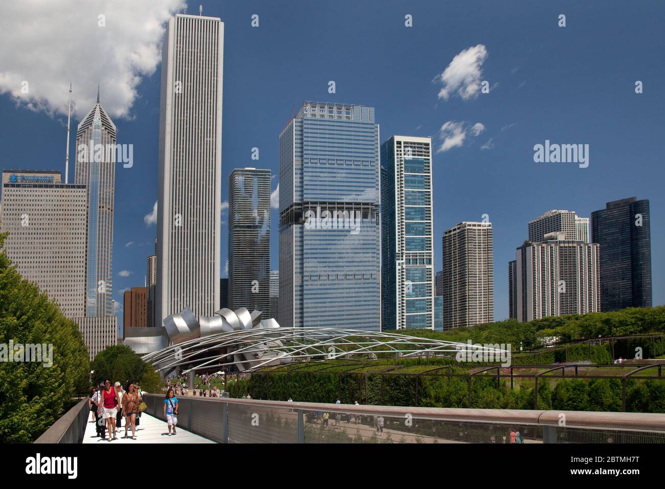 Personnes traversant le pont de Renzo Piano Nichols Bridgeway, avec les gratte-ciel de Chicago et l'auditorium Frank Gehry (Pritzker Pavilion) comme arrière-plan, Millenium Park Banque D'Images