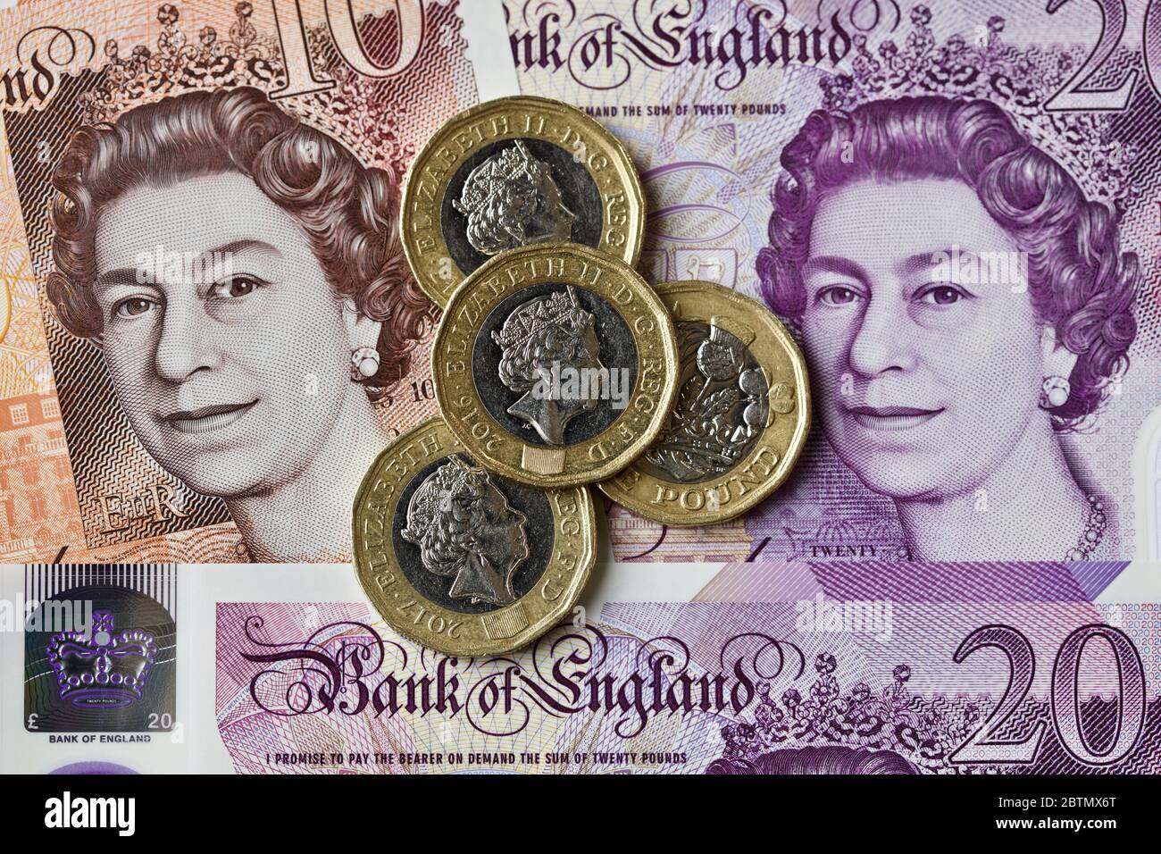 Billets britanniques et pièces de une livre Banque D'Images