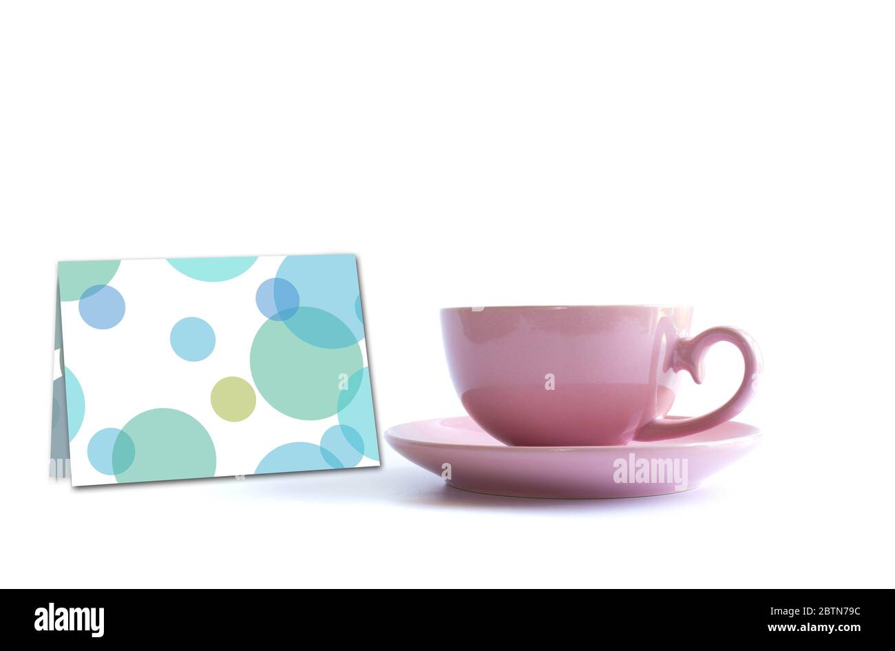 Tasse de thé en porcelaine rose avec carte de vœux sur fond blanc. Carte, affiche, maquette. Célébration, anniversaire, concept d'anniversaire. Banque D'Images