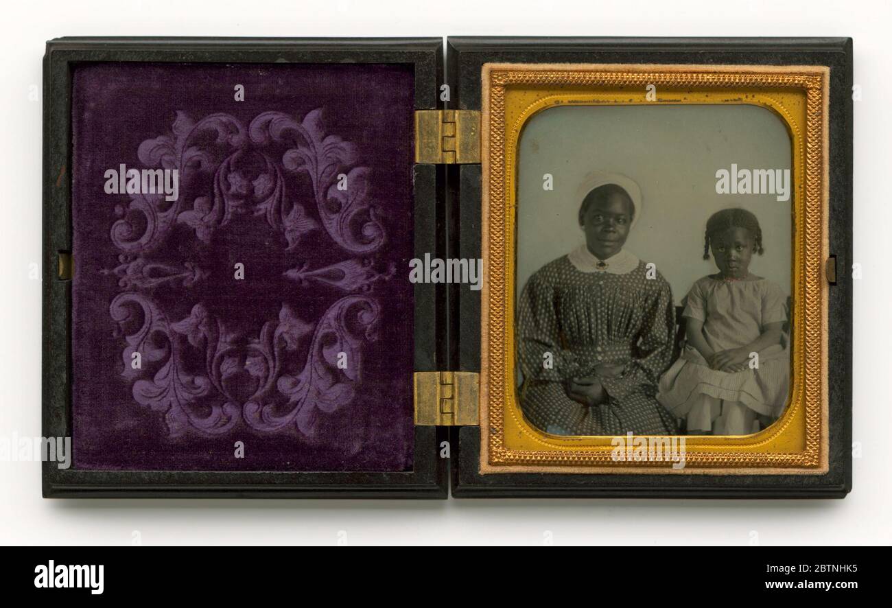 Ambrotype d'une femme et d'un enfant non identifiés. Dans un boîtier thermoplastique noir avec charnières en laiton et une décoration en médaillon d'or et une doublure mauve est un ambrotype dans un preserrateur en laiton et papier et tapis d'une femme afro-américaine avec une casquette blanche ou un foulard dans une robe à motifs avec un col blanc et une broche. Banque D'Images