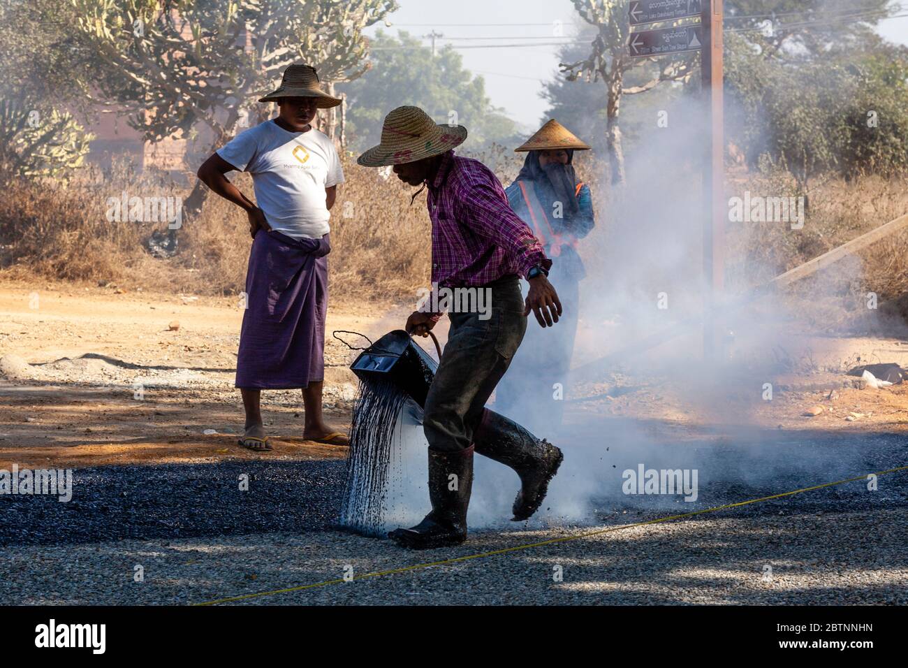 Les hommes locaux font le resurfaçage D'UNE route, Bagan, région de Mandalay, Myanmar. Banque D'Images