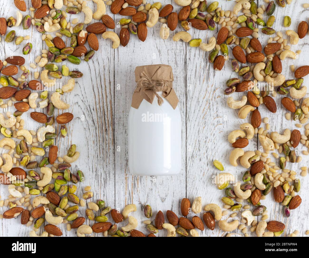 Du lait végétalien à base de noix sur une table rustique en bois Banque D'Images