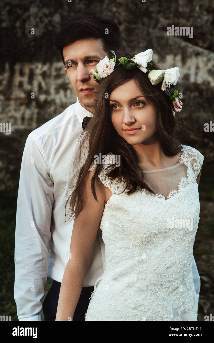 joyeux marié élégant et jeune mariée de boho élégant posant au coucher du soleil dans les montagnes Banque D'Images