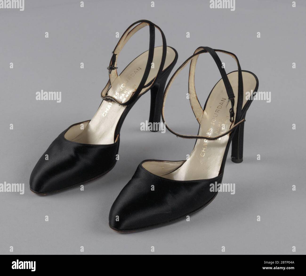 Paire de chaussures noires à talons aiguilles par Charles Jourdan de la  boutique de souvenirs de la Millinery. Une paire de chaussures noires à  bout fermé en satin avec talons aiguilles et