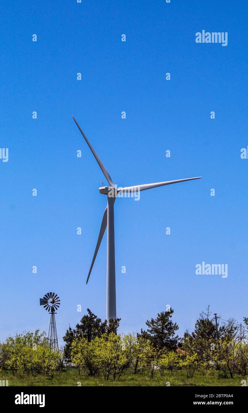 Ancien et nouveau. Photo d'un ancien moulin à vent par rapport aux nouveaux moulins à vent d'aujourd'hui Banque D'Images