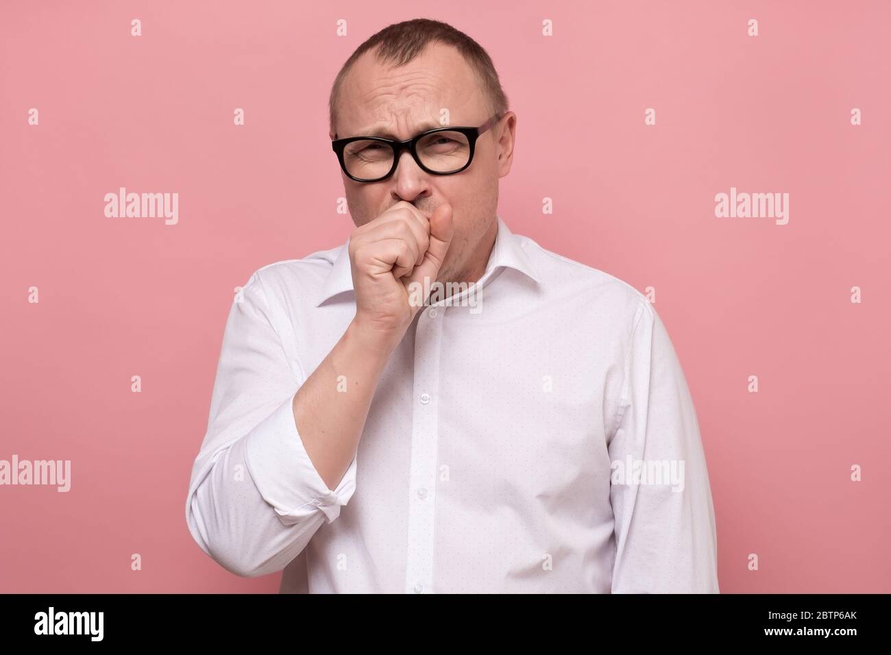 Homme caucasien mature dans les verres toux à cause de la grippe. Banque D'Images