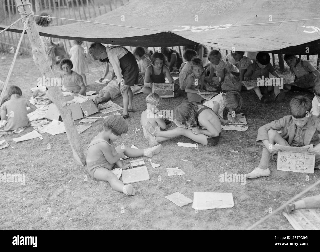 Enfants lisant des bandes dessinées . 1937 Banque D'Images
