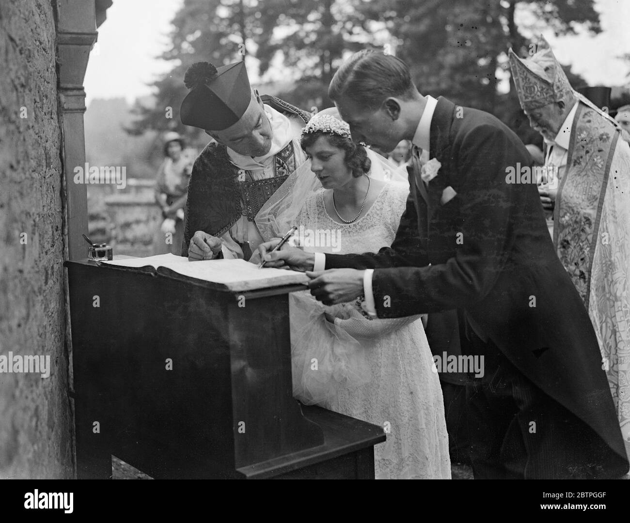 Chèvre comme invité de mariage . Le village de Surrey s'avère regarder la traversée triomphale de la mariée à travers des routes à fleurs . Mlle Brenda Beryl Jarvis , fille cadette de Sir John et Lady Jarvis de Hascombe court , près de Godalming , Surrey , Et il épouse M. Francis Williams , fils du Col Lawrence Williams d'Anglesey , passa sous des arches triomphales le long d'une route de campagne à fleurs après leur mariage à St Peters , l'église du village à Hascombe . Tout le village s'est avéré voir la mariée . Billy , la célèbre mascotte de chèvre du 1er Bataillon du Wesh Regiment , était un invité à la réception , où Banque D'Images