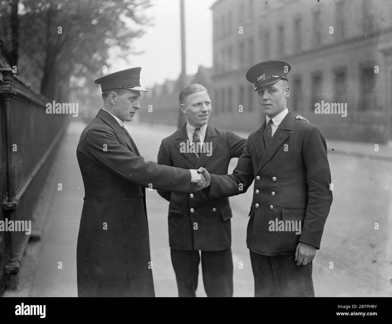 Messager héroïque de Londres garçon . James Dunn , messager ferroviaire employé à la gare d'Euston , a sombré entièrement vêtu de la Tamise près de l'Embankment de Victoria et a sauvé Rose Probeck , une jeune fille de Lambeth , Londres , qui était tombée dans l'eau . Il a déjà gagné une médaille pour sauver des vies . James Dunn ( à droite ) étant félicité par l'inspecteur Holmely , le messager en chef d'Euston , après que ses camarades aient reçu la nouvelle de son acte héroïque . 21 juin 1932 Banque D'Images