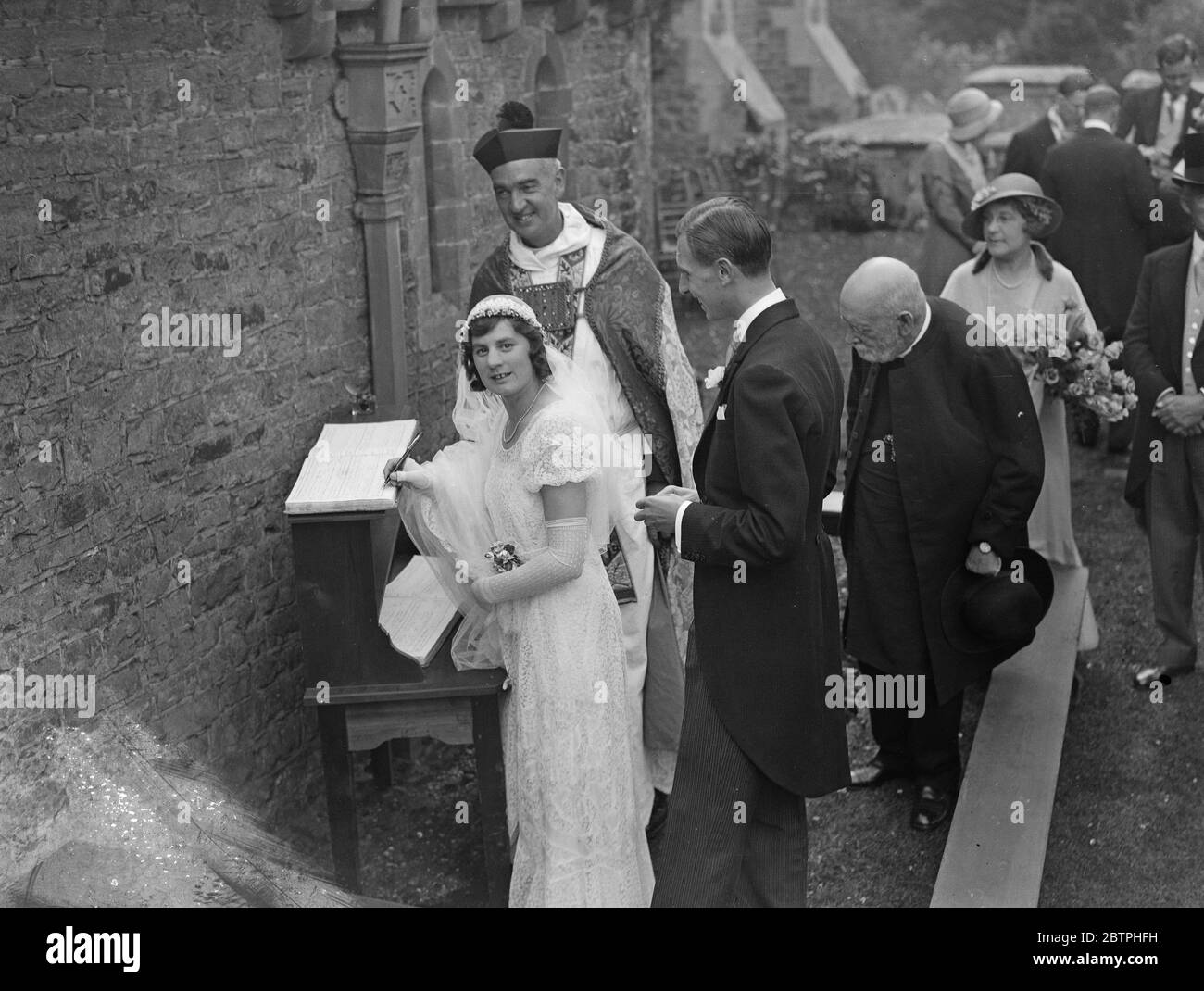 Chèvre comme invité de mariage . Le village de Surrey s'avère regarder la traversée triomphale de la mariée à travers des routes à fleurs . Mlle Brenda Beryl Jarvis , fille cadette de Sir John et Lady Jarvis de Hascombe court , près de Godalming , Surrey , Et il épouse M. Francis Williams , fils du Col Lawrence Williams d'Anglesey , passa sous des arches triomphales le long d'une route de campagne à fleurs après leur mariage à St Peters , l'église du village à Hascombe . Tout le village s'est avéré voir la mariée . Billy , la célèbre mascotte de chèvre du 1er Bataillon du Wesh Regiment , était un invité à la réception , où Banque D'Images