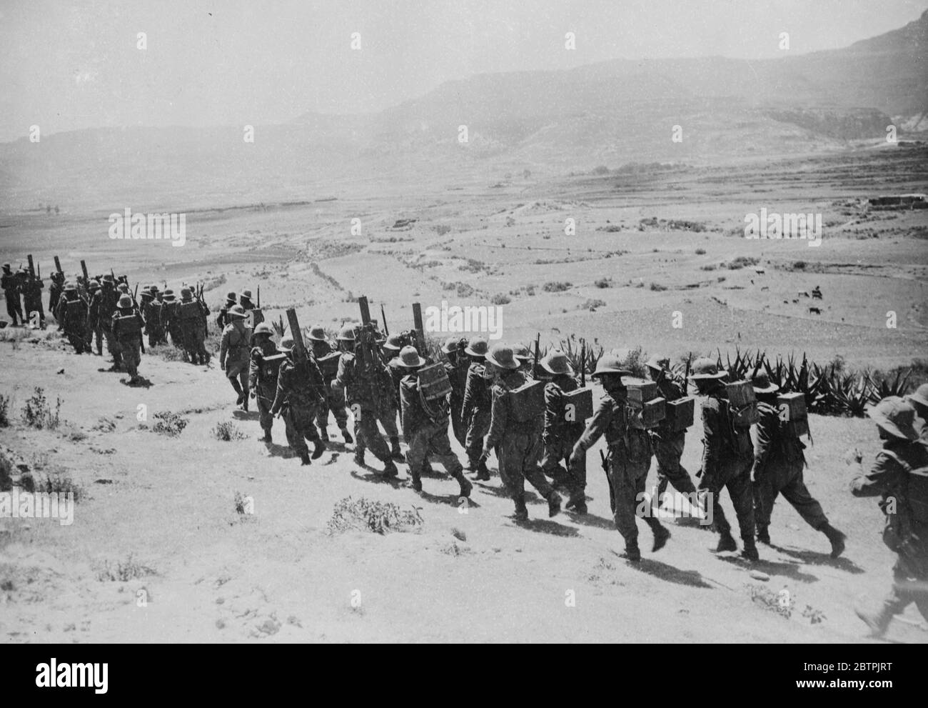 Les troupes marchèrent dans le désert . Une colonne de troupes italiennes transportant des armes lourdes et du matériel sur leur dos marchant dans le désert pendant l'avance dans le secteur Adigrat . 26 octobre 1935 Banque D'Images