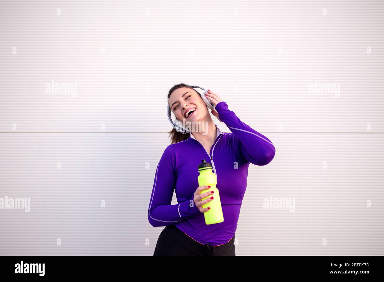 Fille sportive posant avec une bouteille jaune sur sa main Banque D'Images