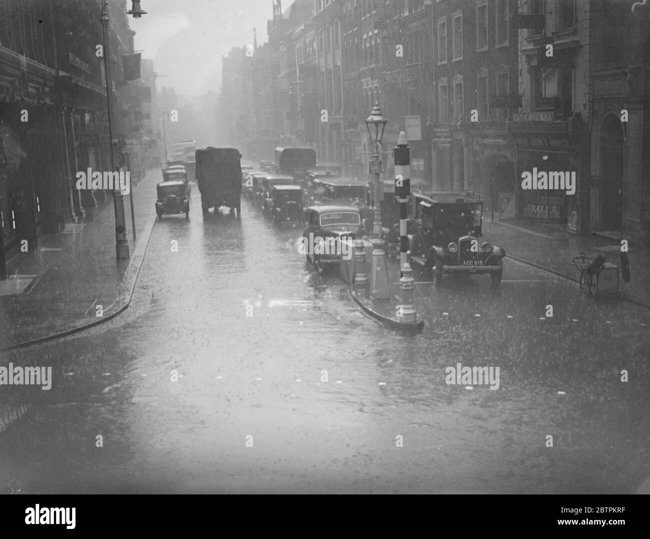 Les Londoniens délurés de Londres furent envoyés à l'abri de la pluie qui s'enferra dans des torrents . Photos : UNE scène au large de Regent Street pendant la pluie. 9 juillet 1936 Banque D'Images