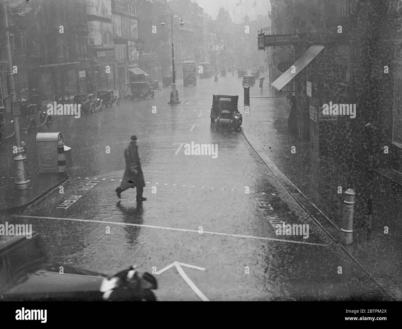 Les Londoniens délurés de Londres furent envoyés à l'abri de la pluie qui s'enferra dans des torrents . Photos : Haymarket pendant la pluie . 9 juillet 1936 Banque D'Images