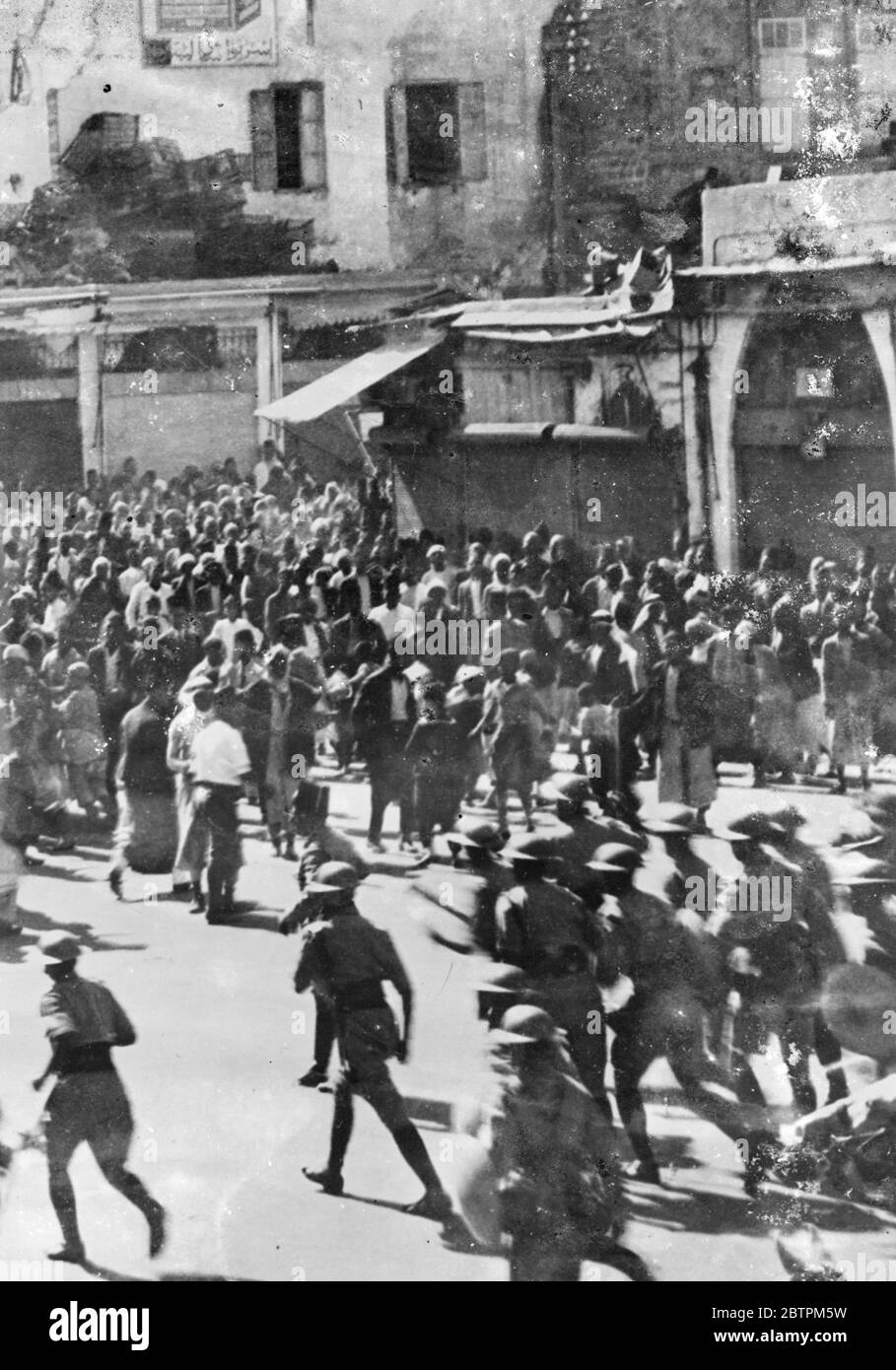 La police britannique attaque la foule arabe à Jaffa . Pire situation . Les deux parties ont subi des pertes lorsque des manifestants arabes sont entrés en conflit avec la police britannique près de la mosquée de Jaffa . La situation est maintenant si grave à Jaffa qu'un couvre-feu de 7 heures a été imposé. Quiconque vu dans les rues après cette heure risque d'être abattu par des patrouilles . Photos : la police britannique avance sur la foule arabe près de la mosquée de Jaffa . 11 juin 1936 Banque D'Images