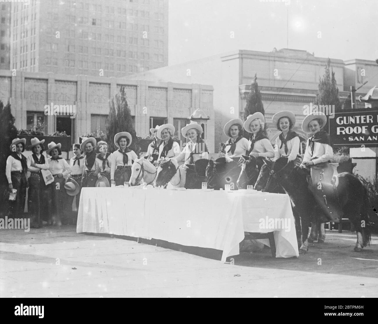 Déjeuner à cheval. Les filles du Texas se préparent à l'exposition centenaire . Préparer tout le cœur pour la partie qu'ils doivent prendre dans l'exposition , une partie de cinquante filles de vache qui sont formées comme hôtesses pour l'exposition du centenaire du Texas , a pris le déjeuner à cheval à San Antonio , Texas , pendant une visite de l'Etat . L'exposition et la foire de 5 , 000 , 000 se tiennent en juin dans le cadre des célébrations marquant le centenaire de l'émancipation du Texas . Photos spectacles , les hôtesses de la vache de lunch de l'équitation sur le jardin de toit de San Antonio pendant leur visite du Texas . Avril Banque D'Images