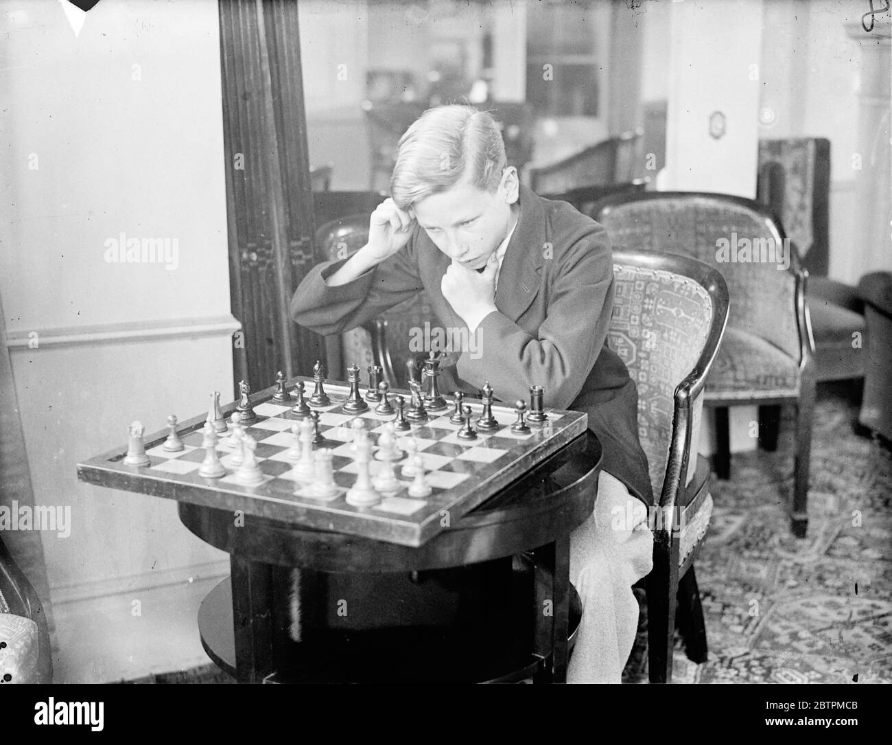 Concentrés de cavernes . Les champions d'échecs de toutes les parties du monde sont en compétition dans le deuxième congrès d'échecs annuel qui a ouvert au Grand Hotel , Margate . Un joueur a établi un nouveau record en voyageant des îles Philippines pour participer . Le plus jeune concurrent est Mlle Elaine Saunders âgée de 10 ans. Photos , T A Cave , en compétition dans la classe des moins de 15 ans , se concentre sur un déplacement difficile . . 16 avril 1936 Banque D'Images